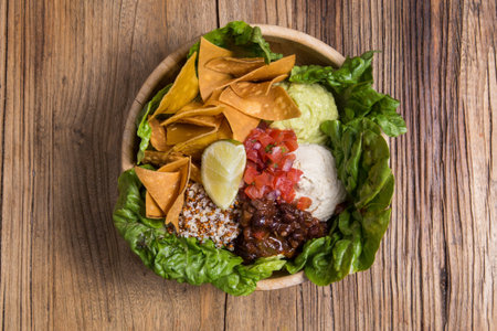 Bowl with nachos, vegetables, quinoa and cheese. Vegan foodの写真素材