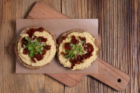 Fresh made toasts with chickpeas hummus served with tomatos. Vegetarian breakfast.の写真素材