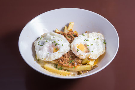 Brocken eggs called huevos rotos, with potatoes and serrano ham