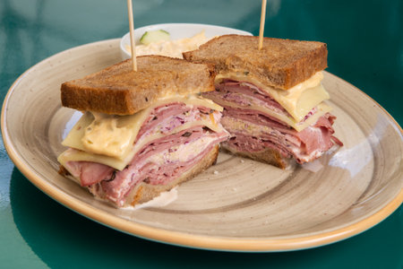 Photo of a club sandwich made with turkey, bacon, ham, tomato, cheese, lettuceの写真素材