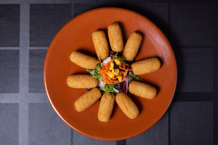 Crispy fried fish fingers with salad and mayonnaise on a plate