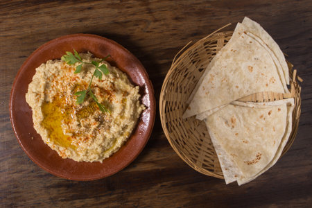 Hummus or houmous, appetizer made of mashed chickpeas, tahini, lemon, garlic, olive oil, parsley and paprikaの写真素材