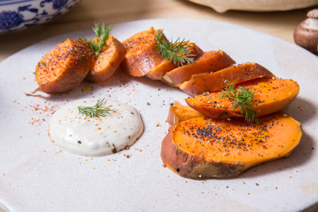 Oven baked sweet potatoes on a plate on vintage wood.の写真素材