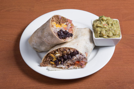 Burrito with beef, beans and tomatoes on a white plateの写真素材