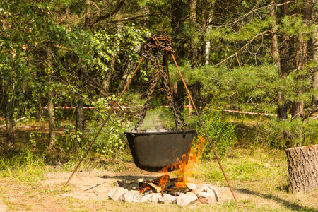Cooking on a fire. Food in a cauldron on a fire. Food outdoors. Cooking outdoors. Cooking in nature on the cauldron.の写真素材