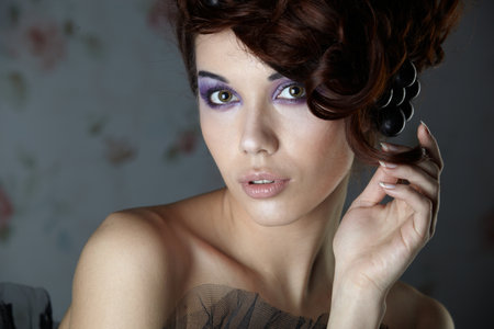 Girl model in a corset on a background wallpaper with flowers in her hair vineの写真素材