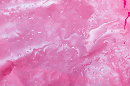 Water drops on glass over textured pink fabric の写真素材