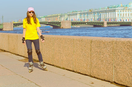 The young girl goes for a drive on rollers along the riverの写真素材