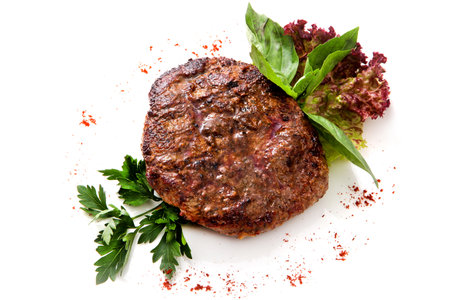 served roast fillet mignon with greens and herbs Isolated on White Background