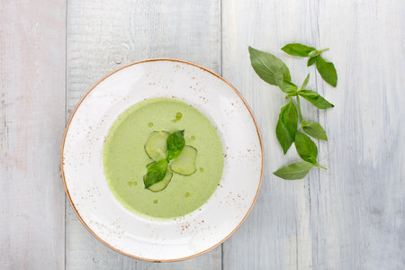 Cold cucumber soup with basil, green on a white wooden background, top viewの写真素材
