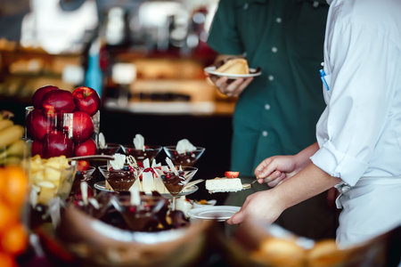 Chef treats guest cheesecake buffet closeup handsの写真素材