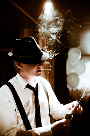 Mobsters sitting and smoking a cigar through smokeの写真素材