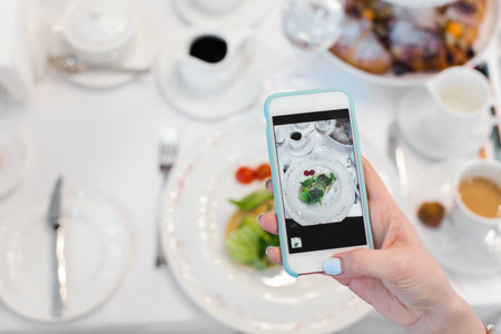 Womans hand smartphone take pictures of breakfastの写真素材