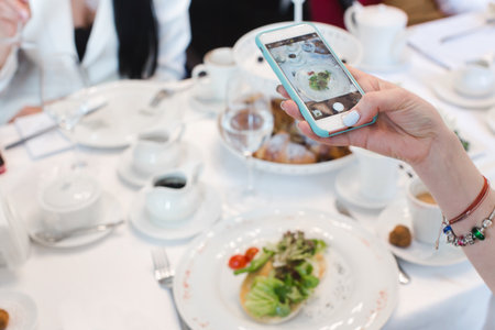 Womans hand smartphone take pictures of breakfastの写真素材