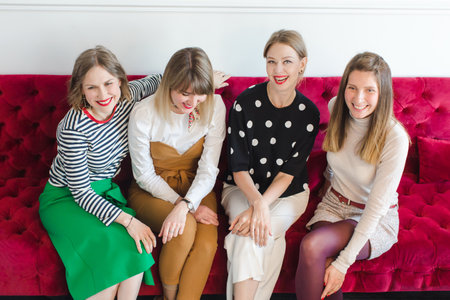 Cheerful women sitting on couchの写真素材
