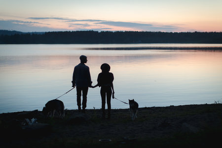 Couple with two dogs on beachの写真素材