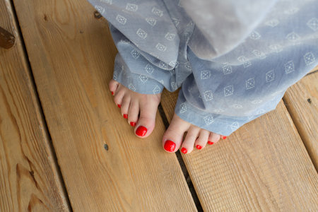 Legs with red pedicure in pajamas, top viewの写真素材