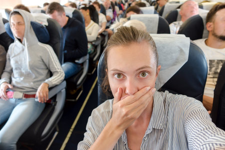 Scared woman in airplaneの写真素材