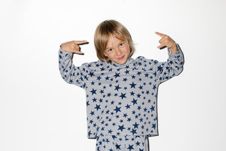 Cute boy gesturing rock at cameraの写真素材