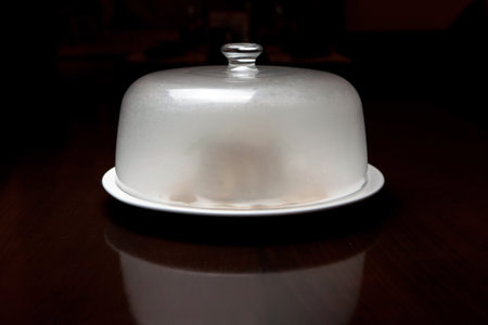 Table with dish closed with glass-made cover. の写真素材