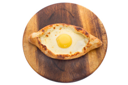 Ajarian khachapuri with egg isolated on a wooden board on a white backgroundの写真素材