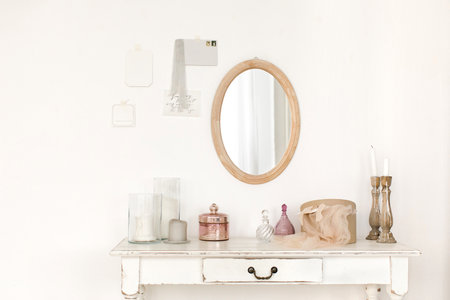 White colored vintage table and mirror hanging on the wall.の写真素材