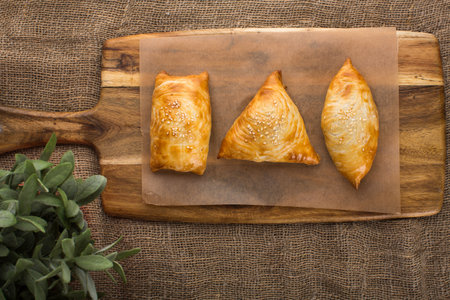 From above of delicious cakes serving on wooden cutting board lying near plantの写真素材