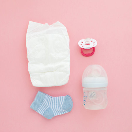 Set for a newborn nipple bottle diaper socks pink background top viewの写真素材