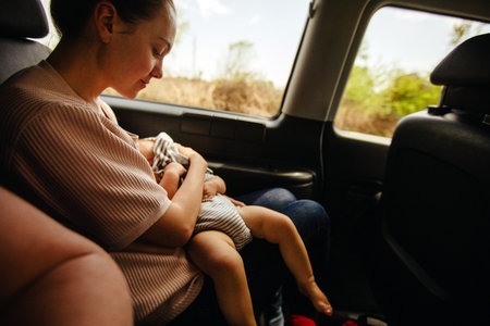 Mother and her sleep baby in car seat