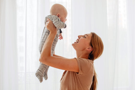 happy family mother playing with newborn baby at home white background