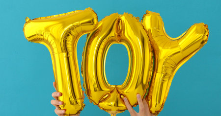 Golden TOY words made of inflatable balloons on blue background