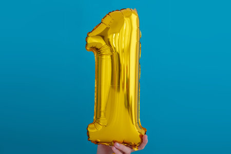 Gold foil number 1 one celebration balloon on blue backgroundの写真素材