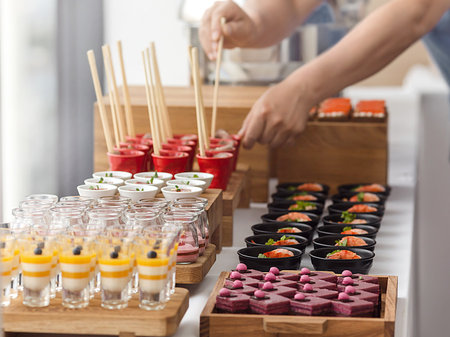 Assorted tasty sweets and pastry served on wooden trays at restaurant buffet