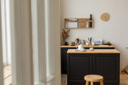 Comfortable light kitchen with table and white tea set reading for tea drinkingの写真素材