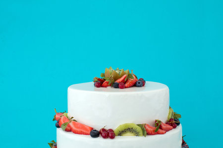 Crop of cake with fresh berries on blue background copy spaceの写真素材