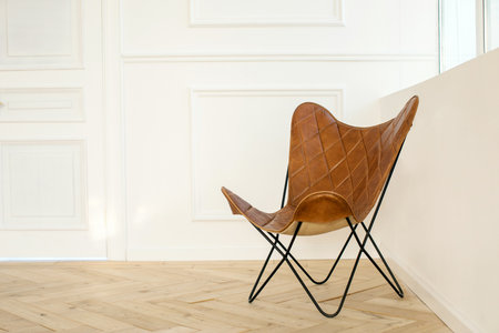 Interior of room with comfortable leather chair on parquet floor and white wallsの写真素材