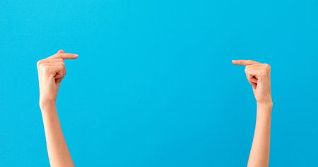 Woman hands pointing on copyspace isolated blueの写真素材