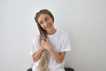 Smiling woman gently touching braided hair