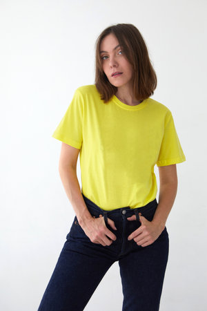Young woman in yellow t shirt white backgroundの写真素材