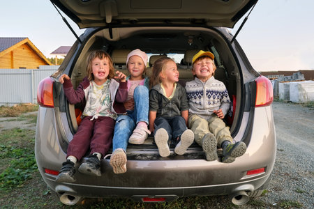 Cheerful children having fun in car trunk