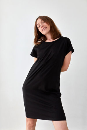 Cheerful woman in black dress in studioの写真素材