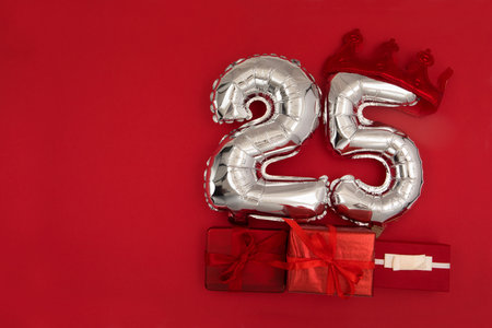 Foil balloons with number 25 on red background