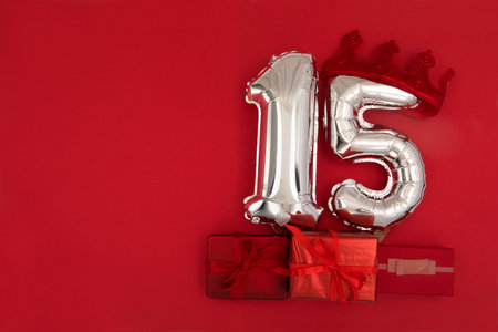 Foil balloons with number 15 fifteen red backgroundの写真素材