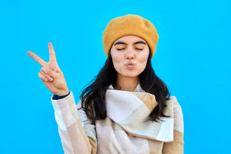 Girl woman is photographed with fingers sign V victory