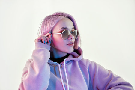 Woman with pink hair in sunglasses on white backgroundの写真素材