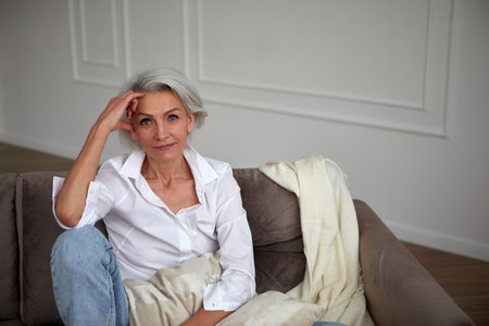Middle aged trendy woman looking at camera at homeの写真素材