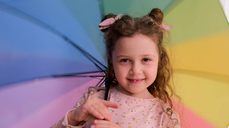 Girl with space buns talks to camera playing with umbrellaの写真素材