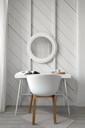 Table near mirror in white wood roomの写真素材