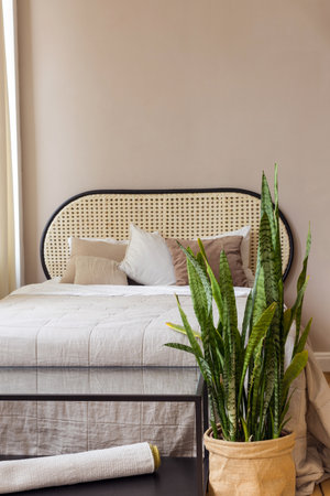 Table and potted plant placed near comfortable bed and staircase in spacious bedroom in modern apartmentの写真素材