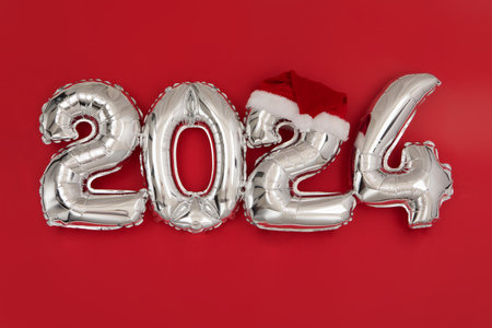 2024 inflatable balloons on red background Santa hatの写真素材